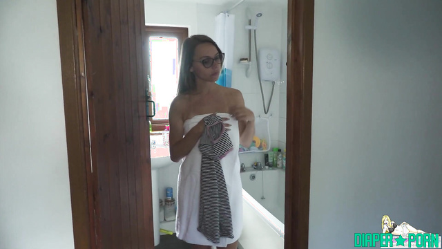 Brunette Chloe stuffing fresh diaper under glasses - UKDiaperGirls