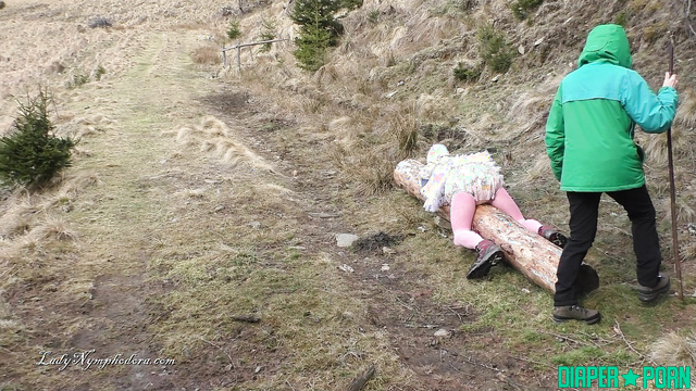 Lady Nymphodora - Pampered babe rubbing his full diaper against a log