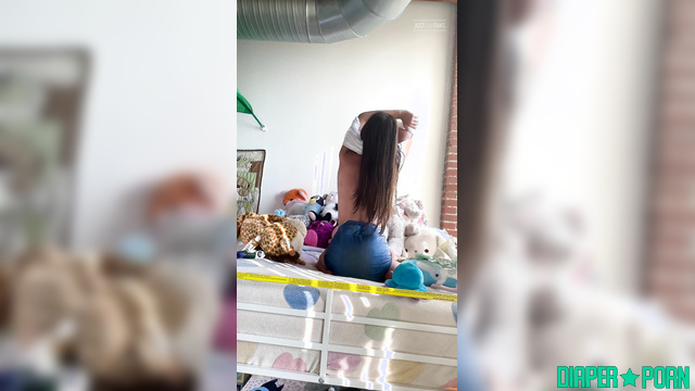 Topless lady with pacifier fooling around on the bed